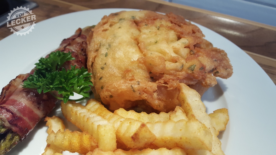 Bierschnitzel mit grünem Spargel im Speckmantel und Pommes