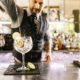 Barmann beim Cocktailmixen mit Gin