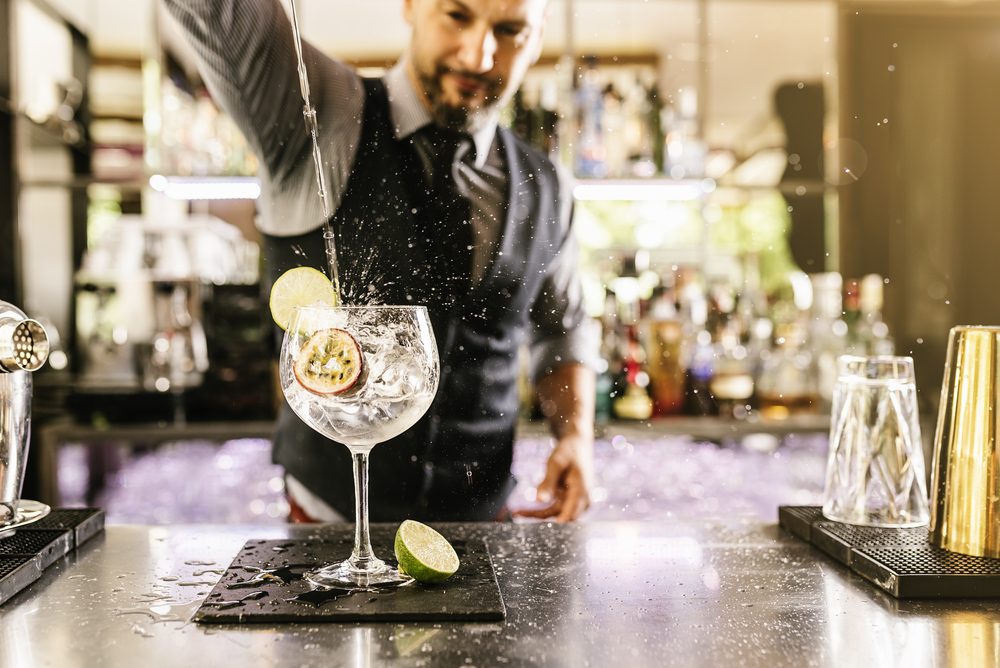 Barmann beim Cocktailmixen mit Gin